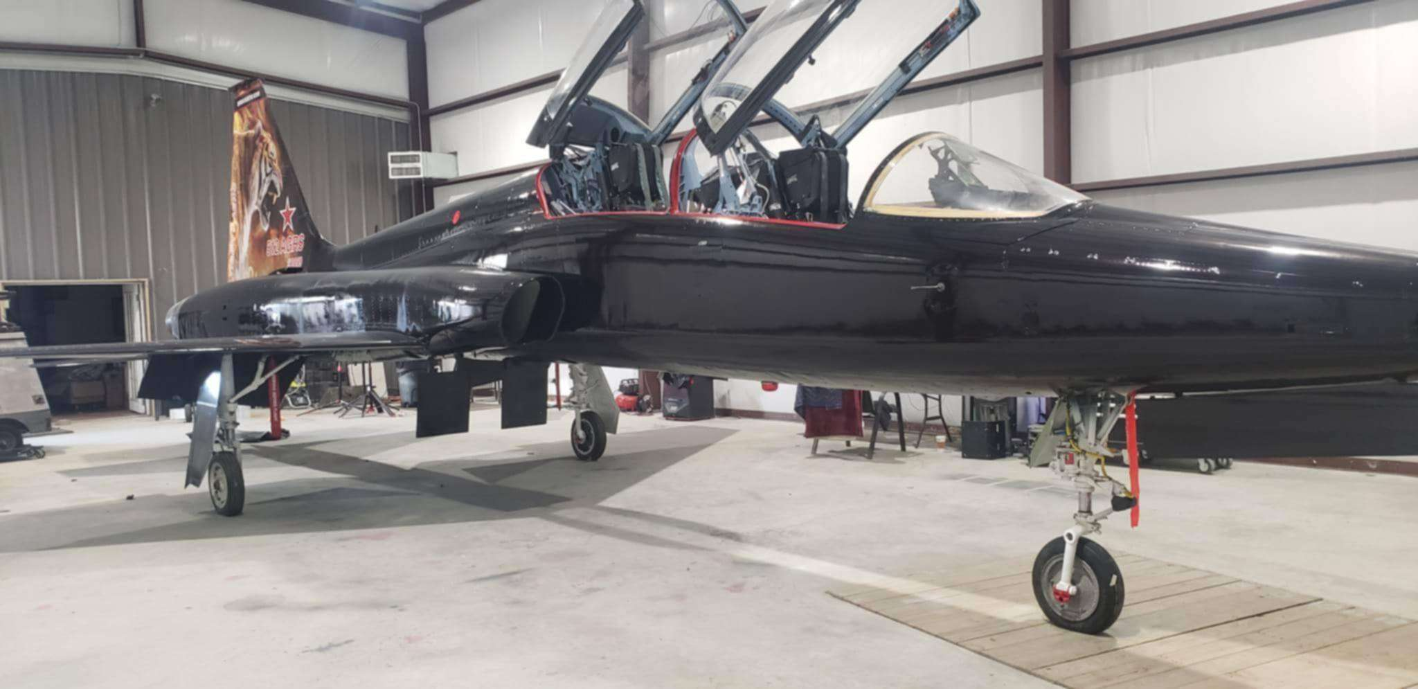 The real Tiger 5 Talon airframe in a workshop, with both canopies open